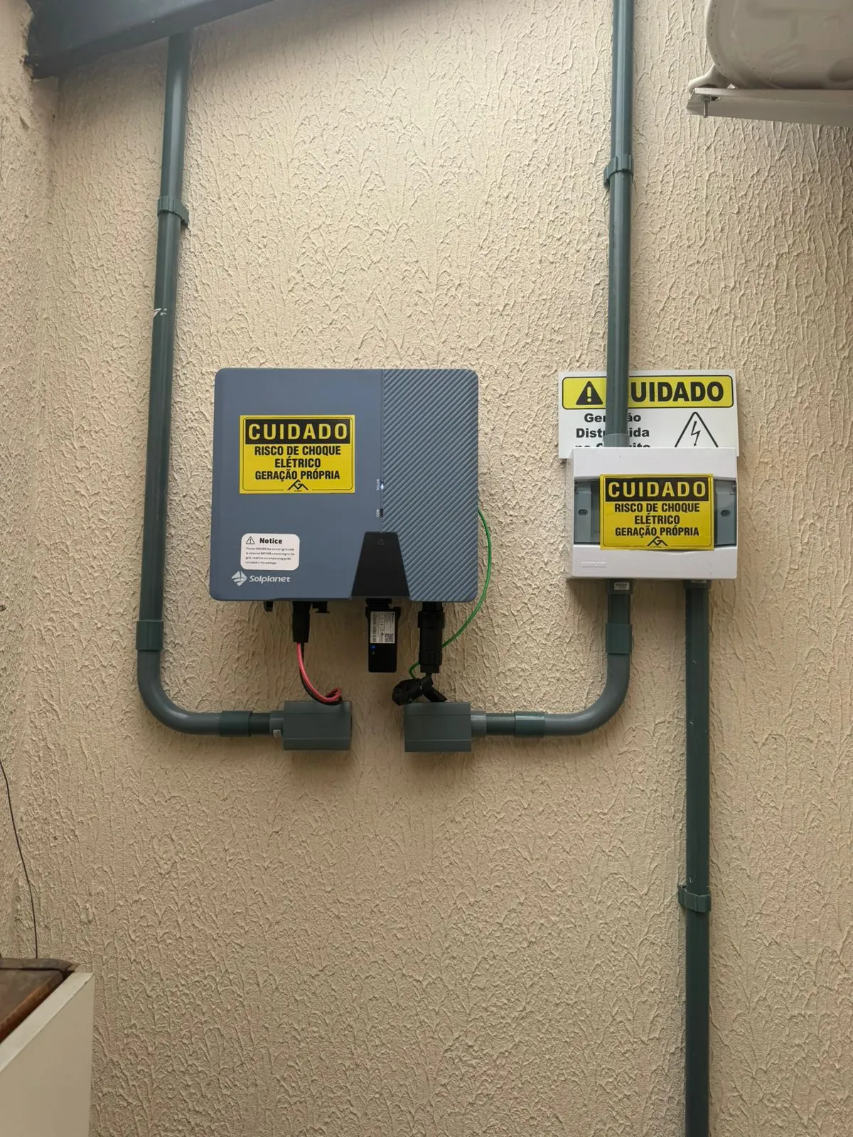 Inversor instalado ao lado do quadro de geração com sinalização de segurança