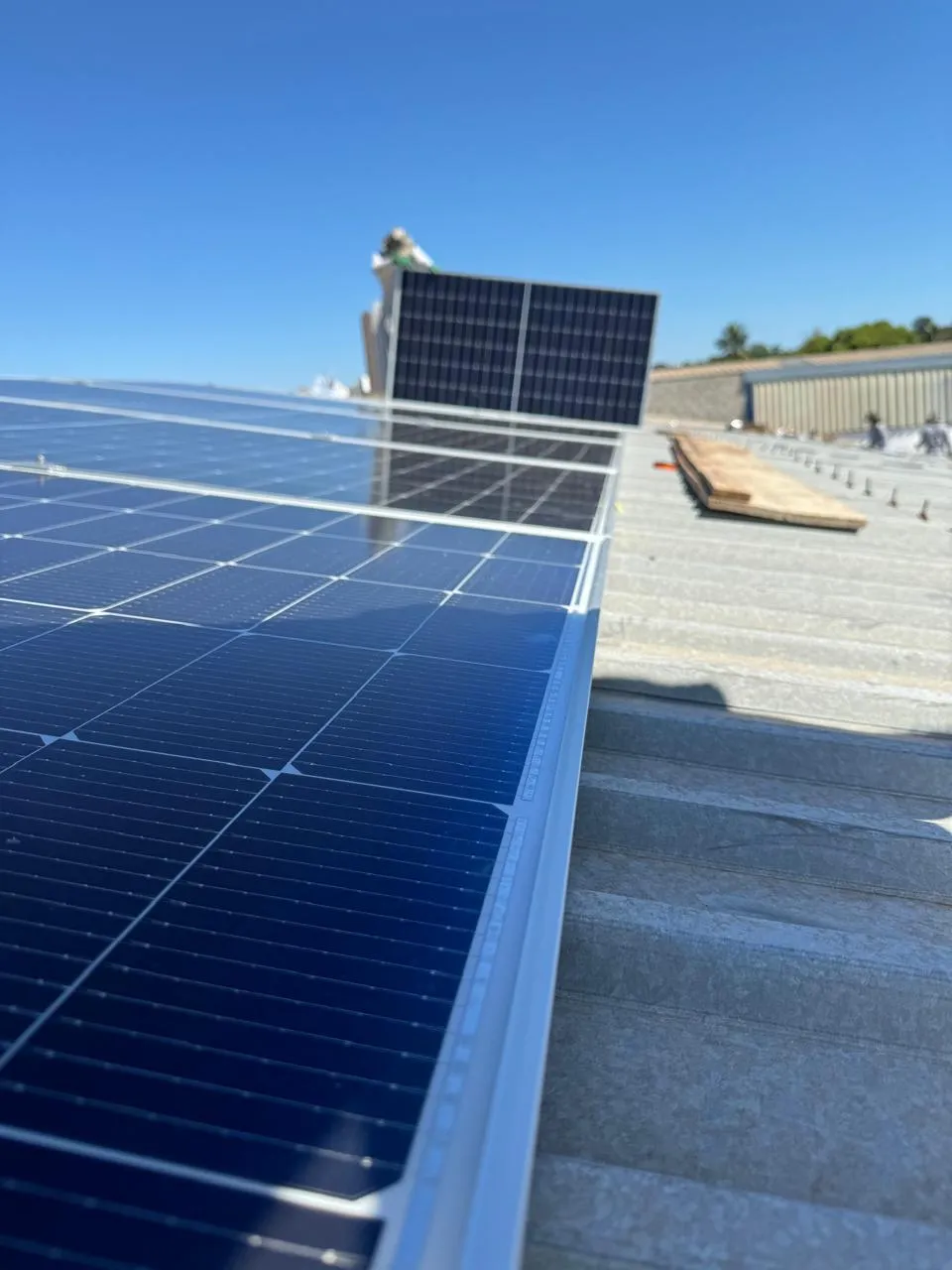 Módulos fotovoltaicos vistos de perto sobre telha metálica trapezoidal